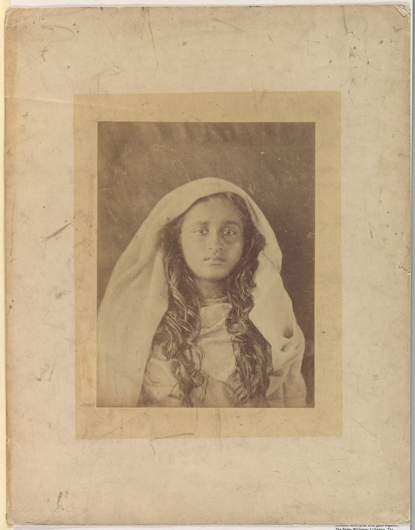 A sepia, head and shoulders photograph of a woman with long dark hair wearing a white veil.