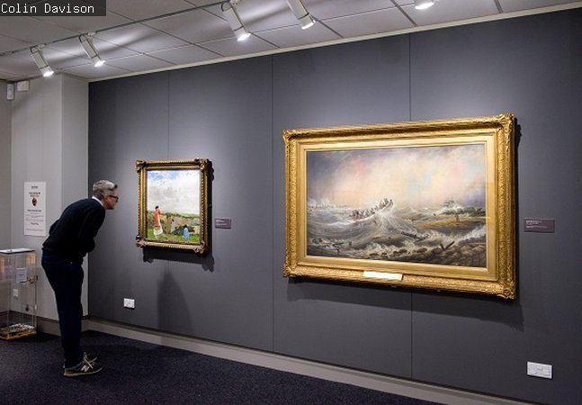Man looks at a picture in the gallery