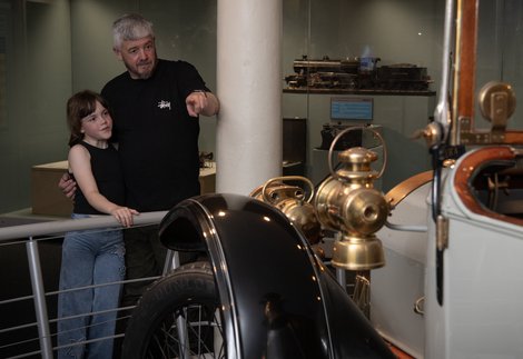 A man and child look at a car on display at Discovery Museum