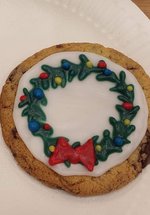 A photograph of two decorated cookies featuring a snowflake and a Christmas wreath