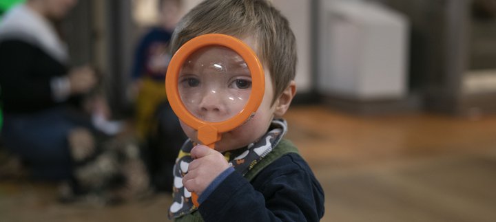 A toddler with a magnifying glass