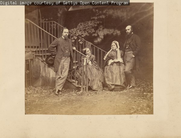 A black and white photograph of Dante Gabriel, Christina, Frances and William Rossetti positioned at the base of an outdoor staircase.