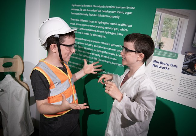two boys smile and chat in the Steam to Green space
