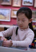 A photograph of a young girl crafting.