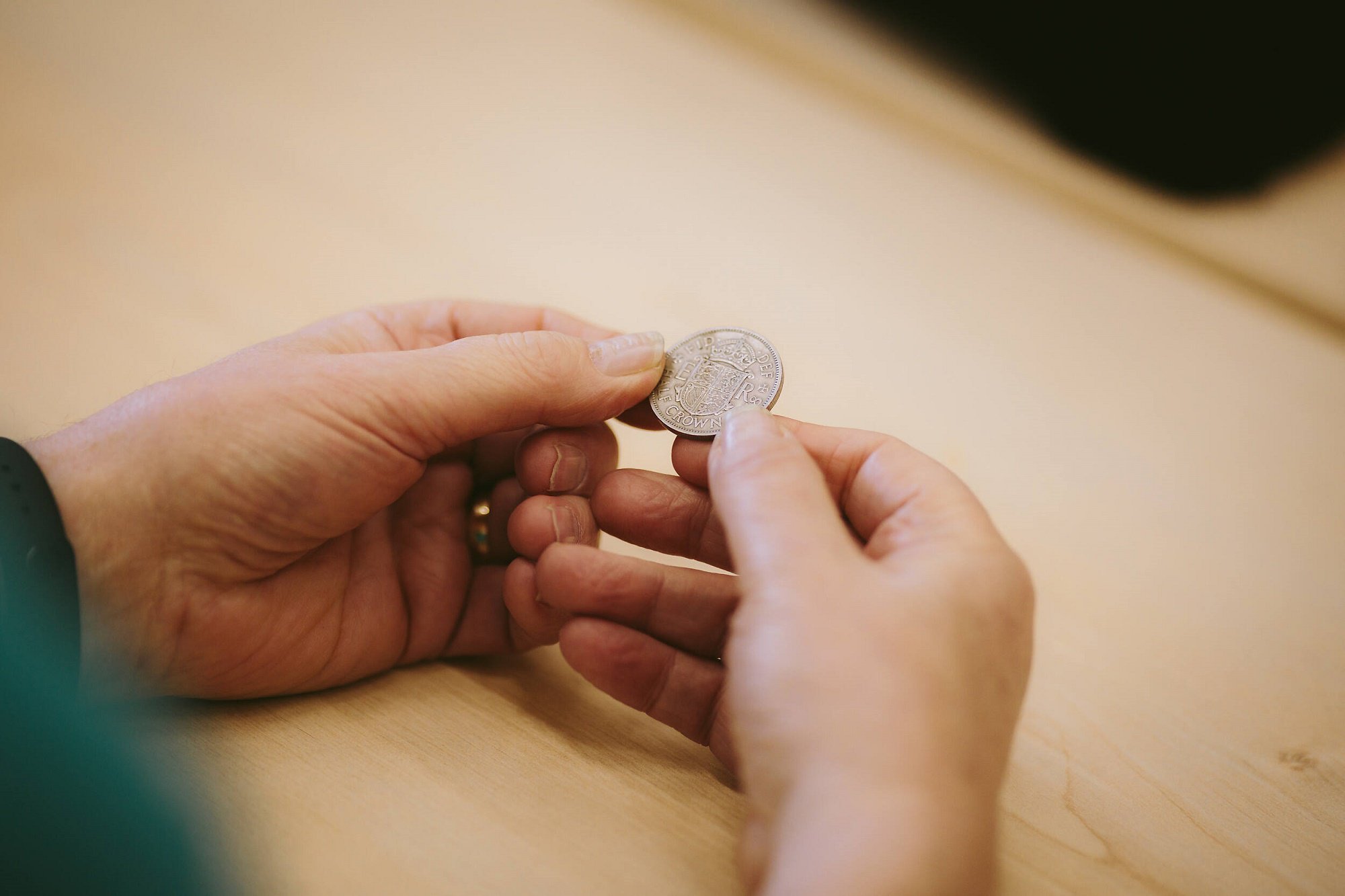 Close-up of hands examining the textures of a historical coin.