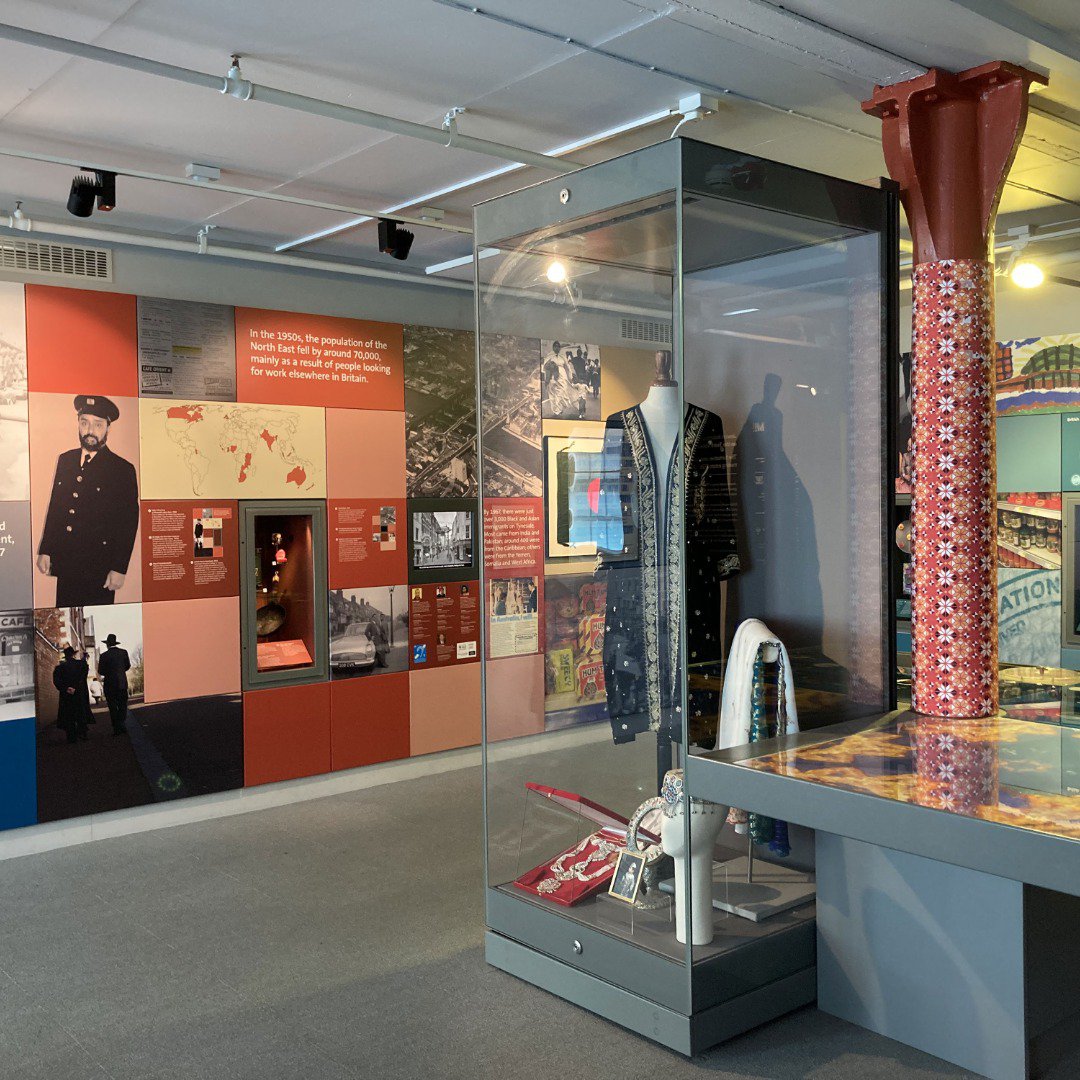 Clothing in a glass display case at a museum Clothing in a glass display case at a museum