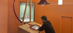 photo of man at desk under trumpet shape 