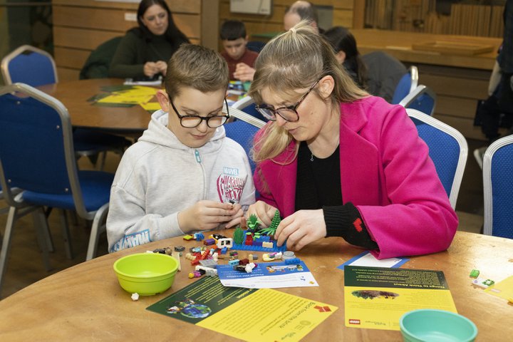 A adult and a child doing a LEGO activity. 