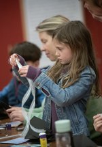 Adults and children taking part in a craft activity together.
