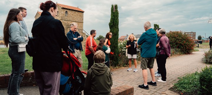 A group of people are gathered around a tour guide