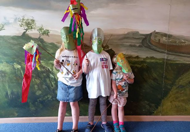Three young children wearing handmade cavalry style masks