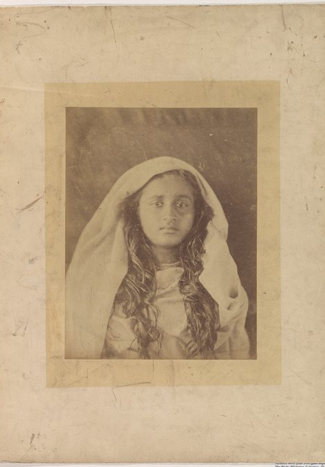A sepia, head and shoulders photograph of a woman with long dark hair wearing a white veil.]