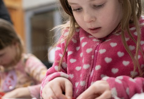 A young child is crafting at a table