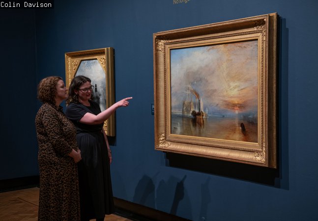 A photograph of two women looking at The Fighting Temeraire