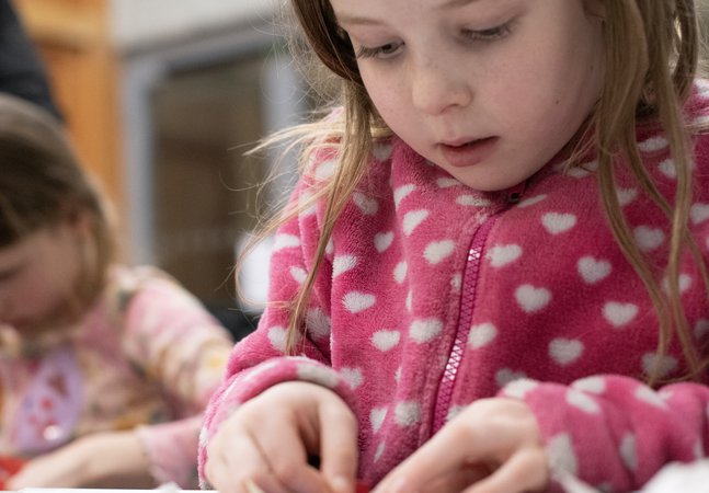 A young child is crafting at a table