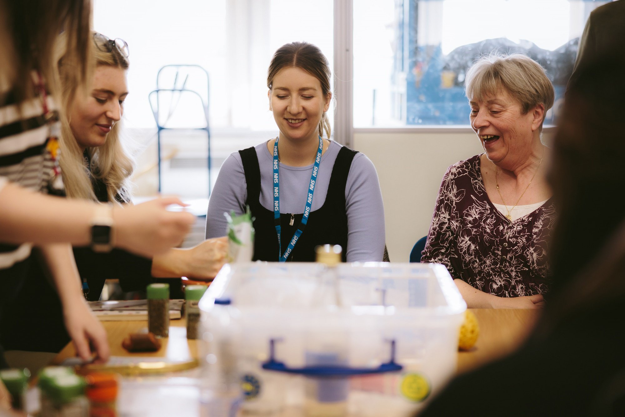 Women at a workshop exploring a box of museum objects and resources.