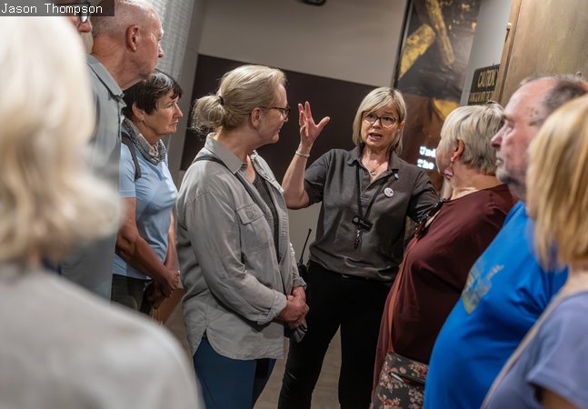 A tour guide giving a group of adults a tour of Woodhorn