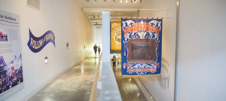 A family walks up an indoor ramp with mining banners hanging from the ceiling