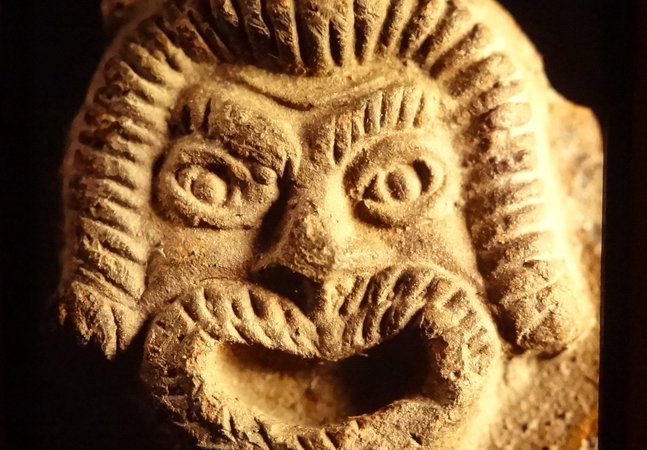 Pottery lamp detail showing a theatrical mask