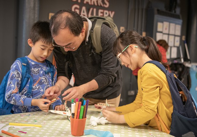 Dad and two children engrossed in craft